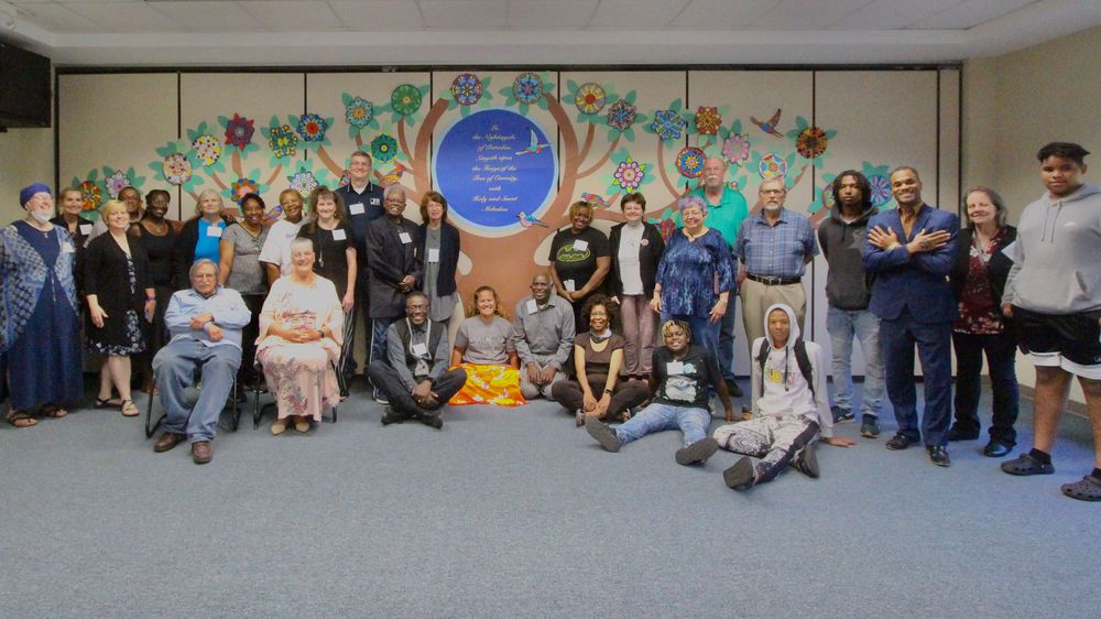 A group photo of the Worldwide Conference in Jackson Mississippi, featuring a "tree of unity" in the background.